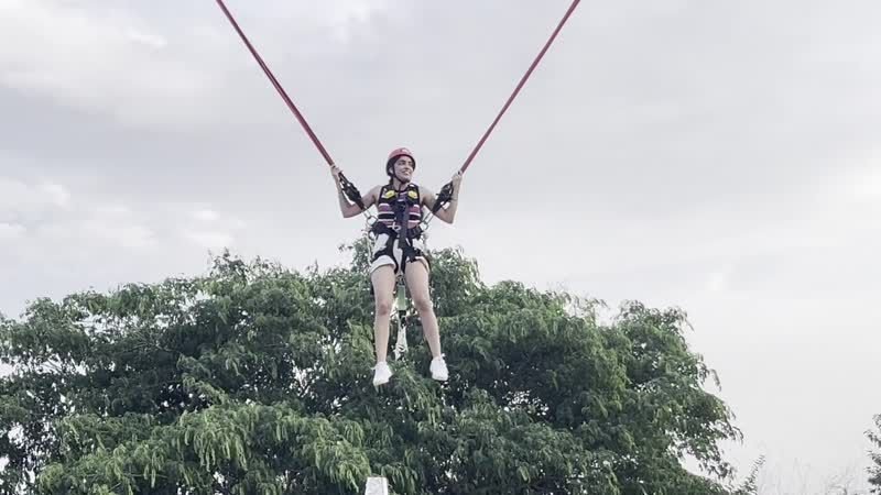 Guest smiling on the giant swing at Elevate